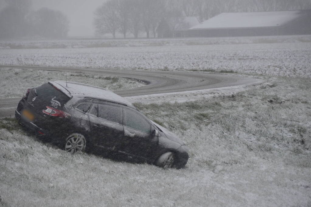Twee personenauto's in berm van dijk belandt