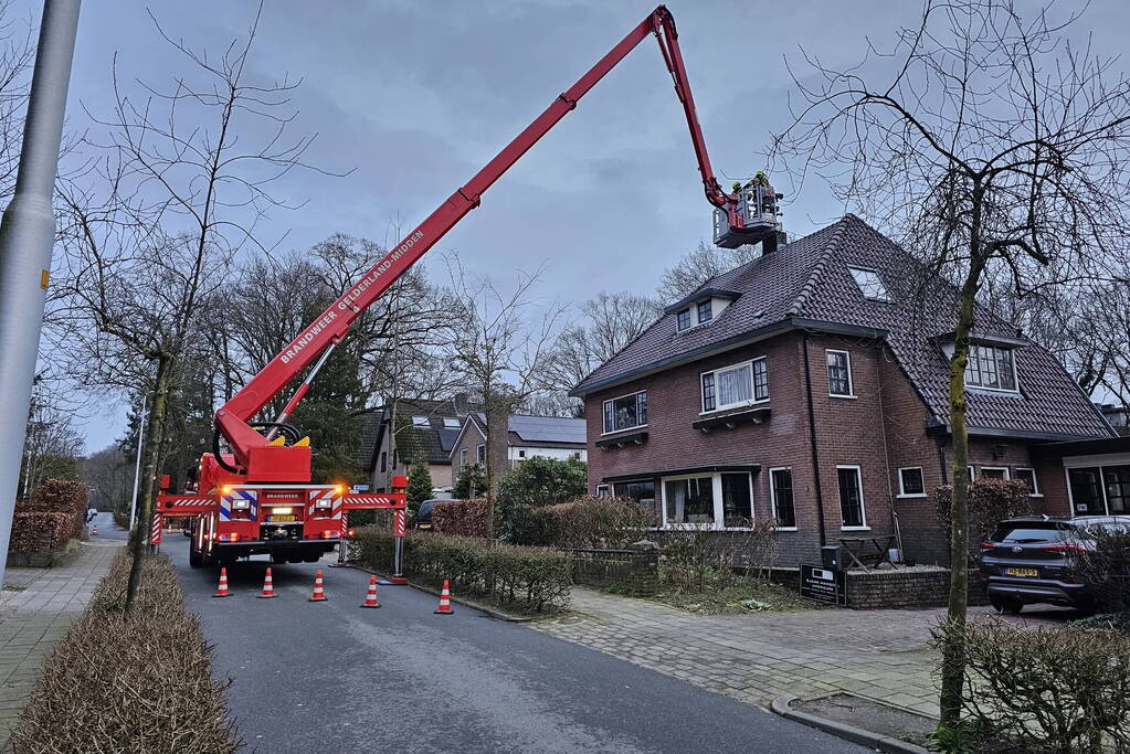 Brandweer veegt schoorsteen na brand