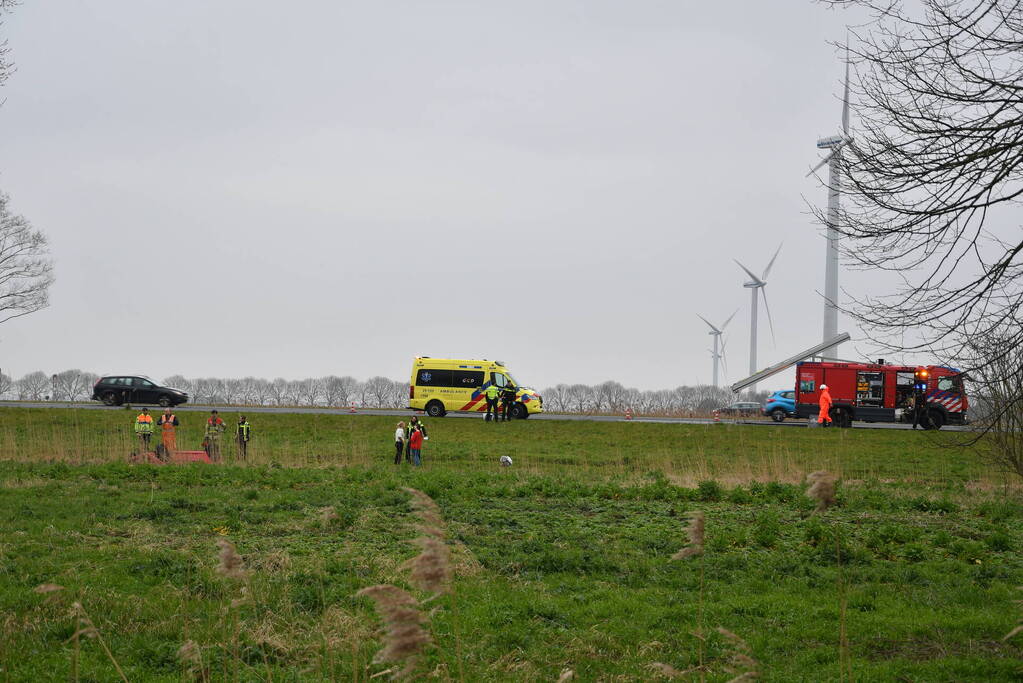 Auto belandt op zijn kop naast snelweg