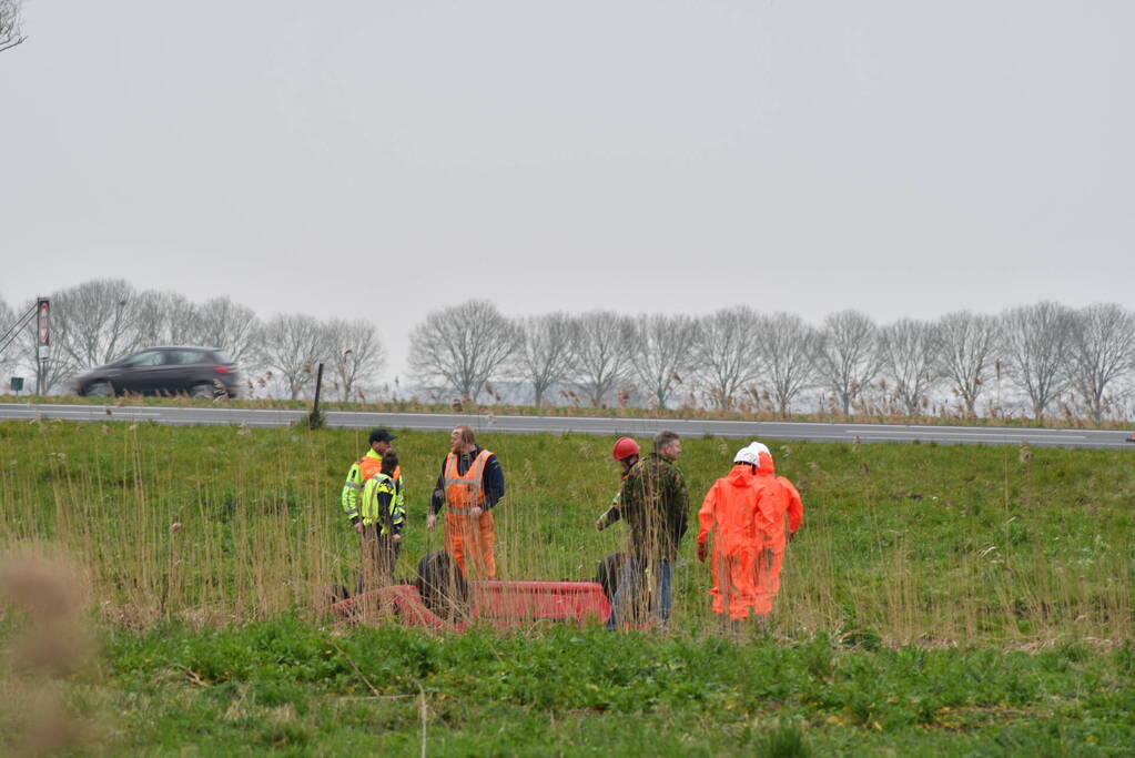 Auto belandt op zijn kop naast snelweg