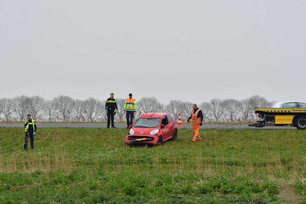 Auto belandt op zijn kop naast snelweg