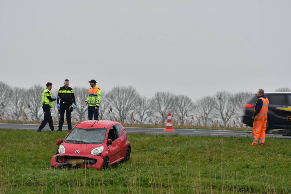 Auto belandt op zijn kop naast snelweg