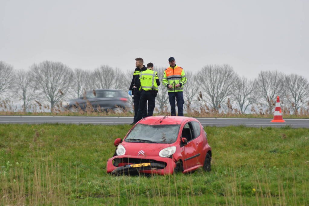 Auto belandt op zijn kop naast snelweg
