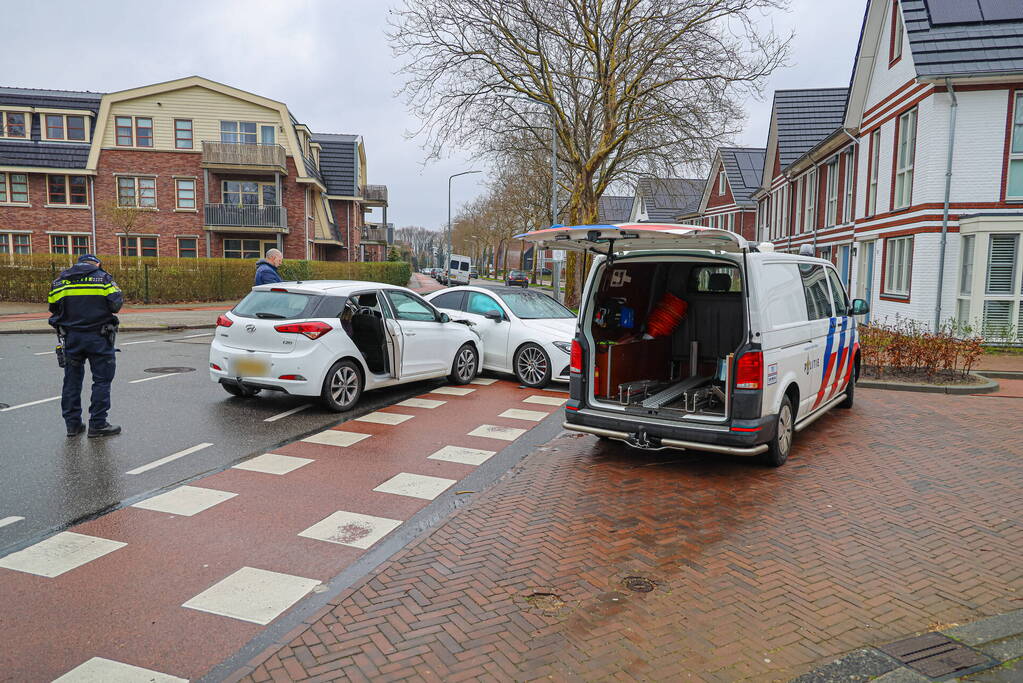 Twee personenauto's botsen op elkaar op kruising