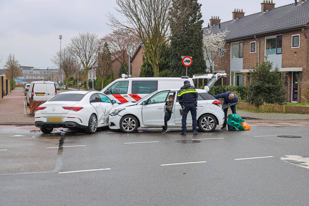 Twee personenauto's botsen op elkaar op kruising