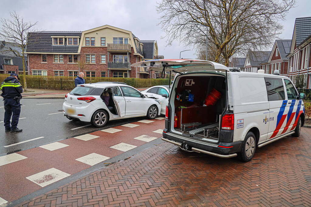 Twee personenauto's botsen op elkaar op kruising