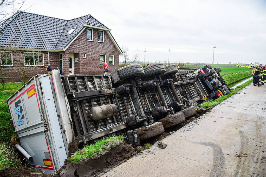 Chauffeur bekneld nadat vrachtwagen in sloot belandt