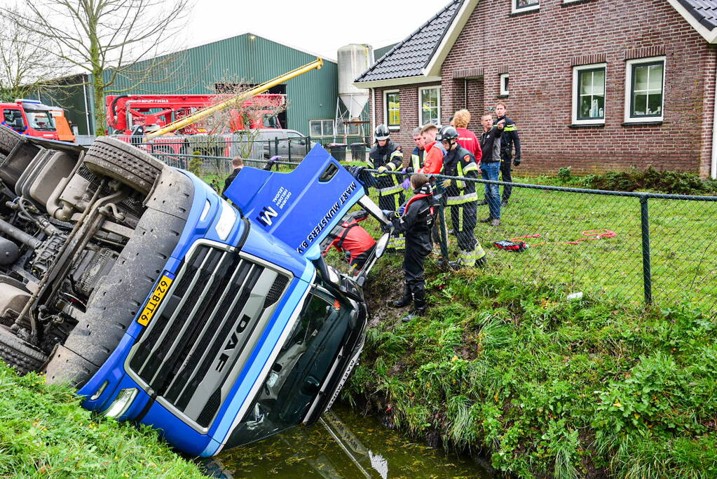 Chauffeur bekneld nadat vrachtwagen in sloot belandt