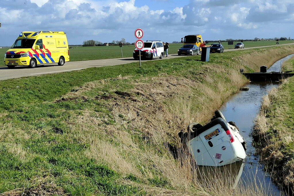 Bestelbus belandt in de sloot na botsing met auto