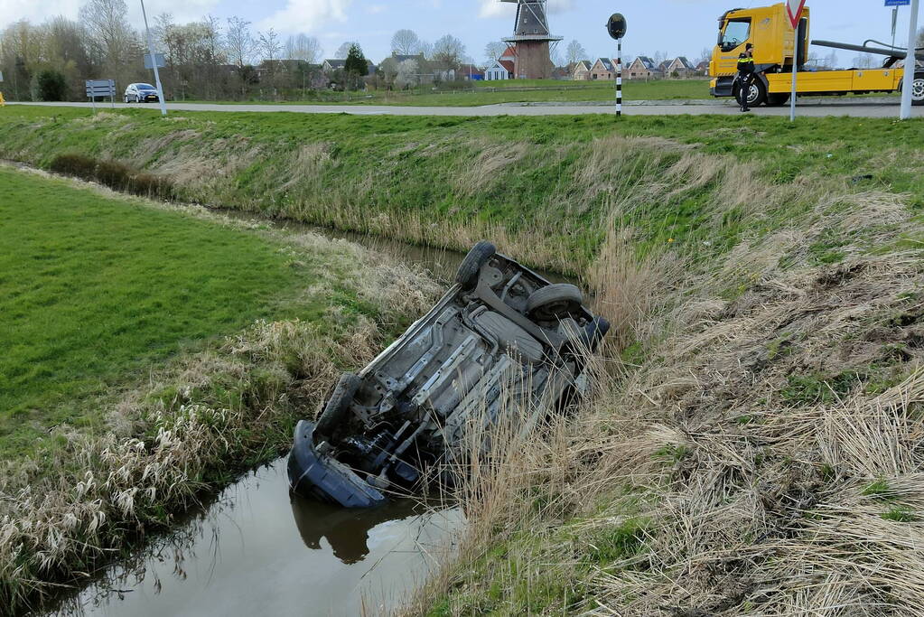 Bestelbus belandt in de sloot na botsing met auto