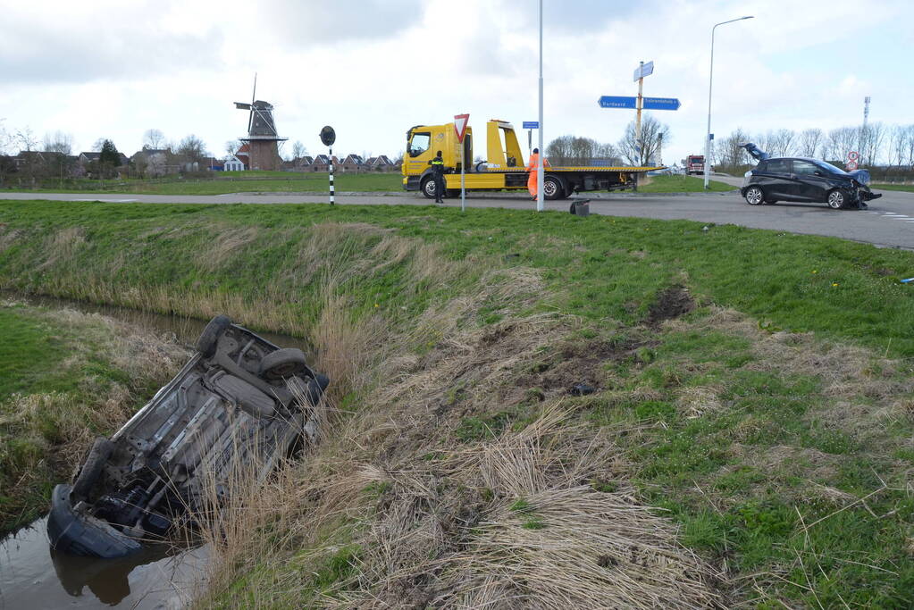 Bestelbus belandt in de sloot na botsing met auto