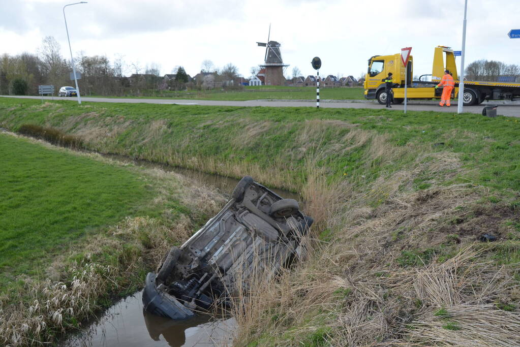 Bestelbus belandt in de sloot na botsing met auto