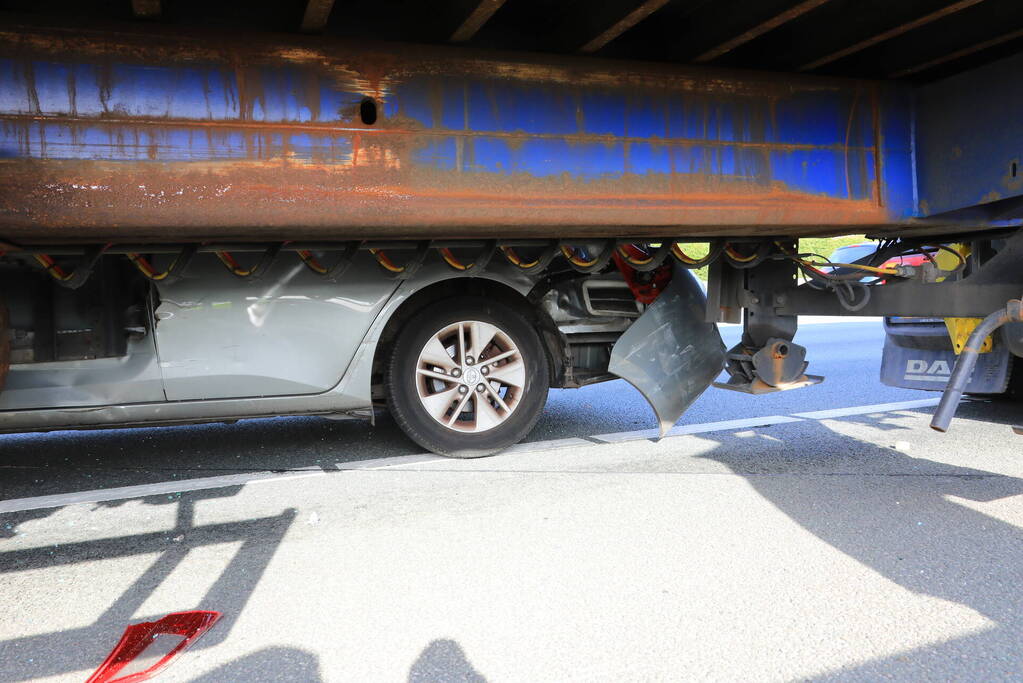 Auto vast onder vrachtwagen oplegger