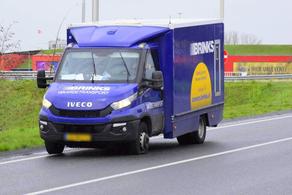 Politie bewaakt geldwagen met lekke band