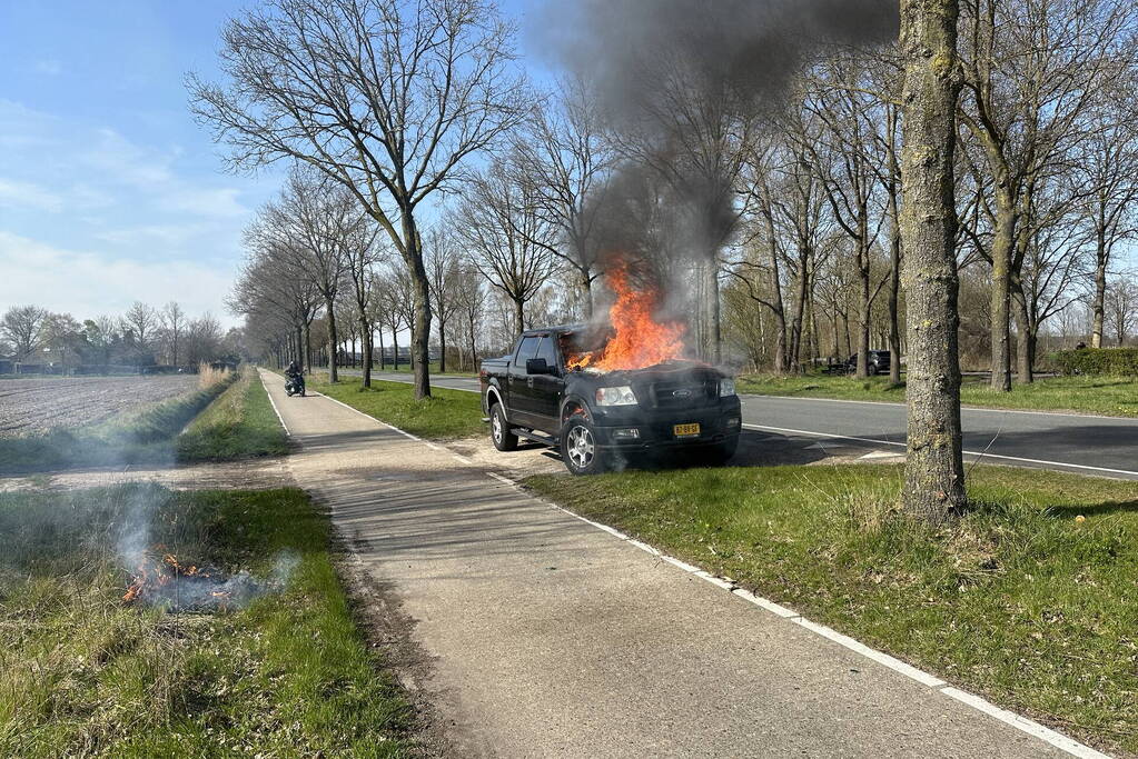 Pickup vliegt onder het rijden in brand