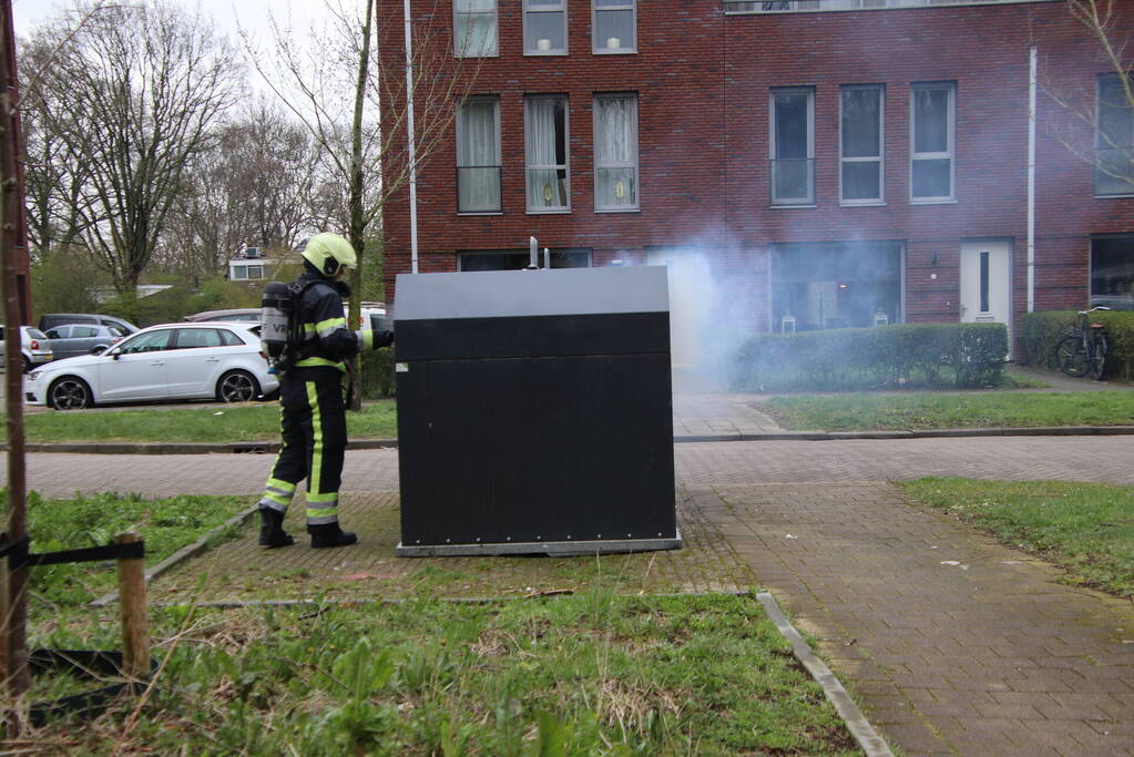 Brandweer blust brand in papiercontainer