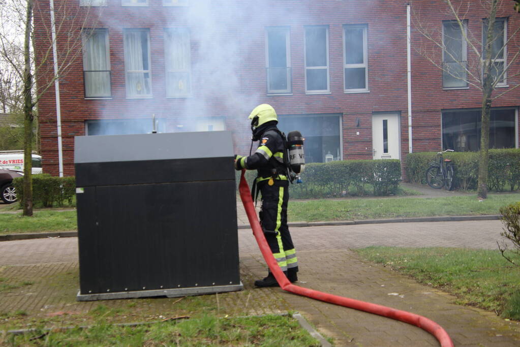 Brandweer blust brand in papiercontainer