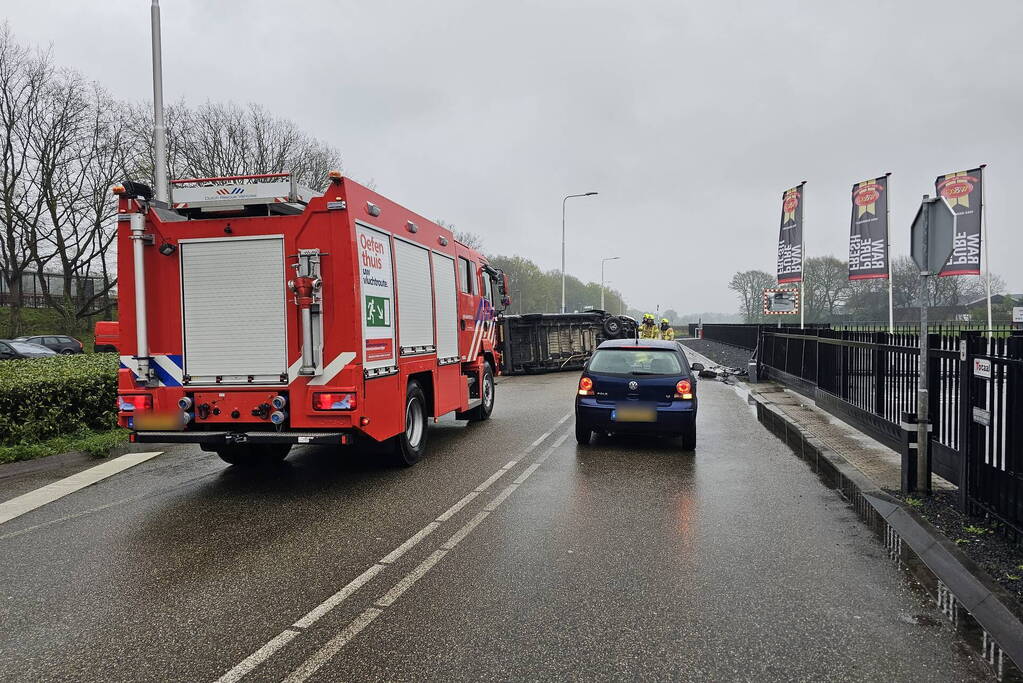 Bestelbus botst op hek en belandt op zijkant