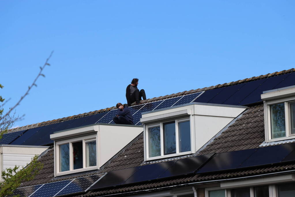 Twee personen op dak van woning