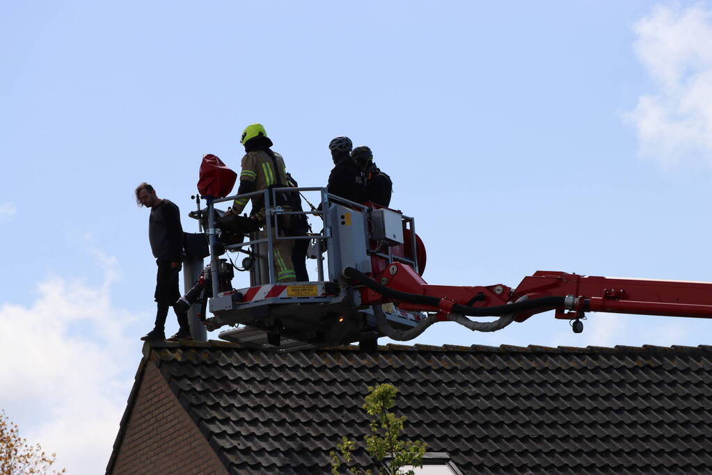 Twee personen op dak van woning
