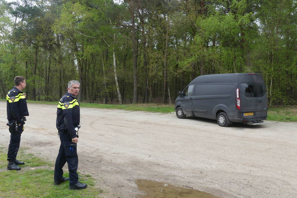 Bestelbus met afval in brand gestoken op parkeerplaats bij bos, twee aanhoudingen