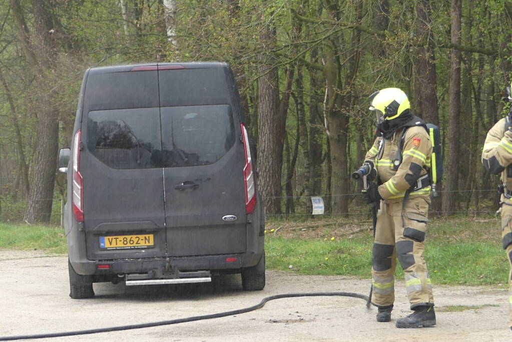 Bestelbus met afval in brand gestoken op parkeerplaats bij bos, twee aanhoudingen