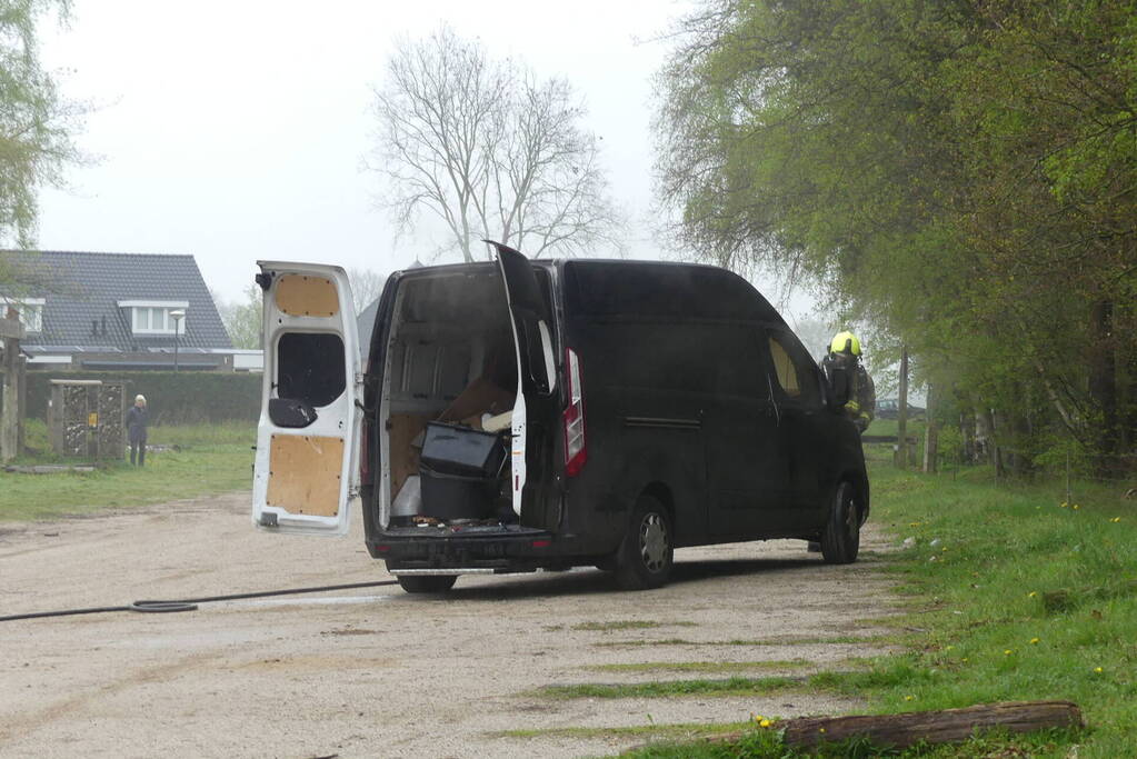 Bestelbus met afval in brand gestoken op parkeerplaats bij bos, twee aanhoudingen