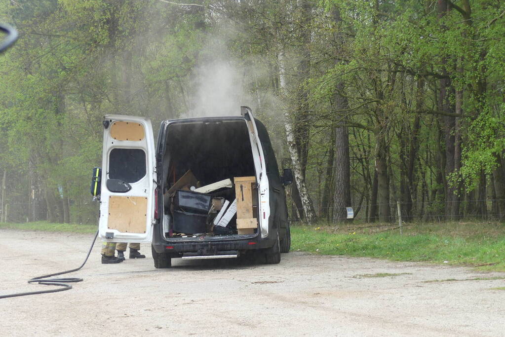 Bestelbus met afval in brand gestoken op parkeerplaats bij bos, twee aanhoudingen