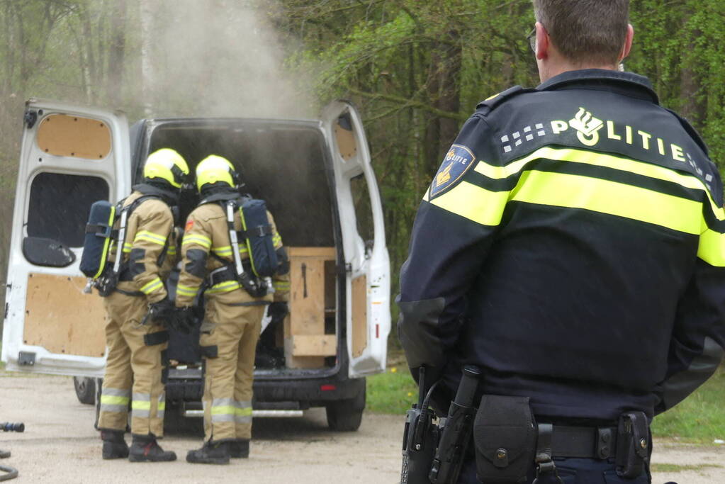 Bestelbus met afval in brand gestoken op parkeerplaats bij bos, twee aanhoudingen