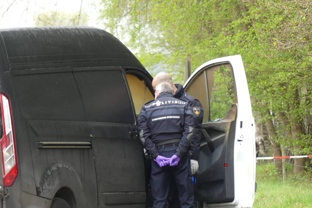 Bestelbus met afval in brand gestoken op parkeerplaats bij bos, twee aanhoudingen