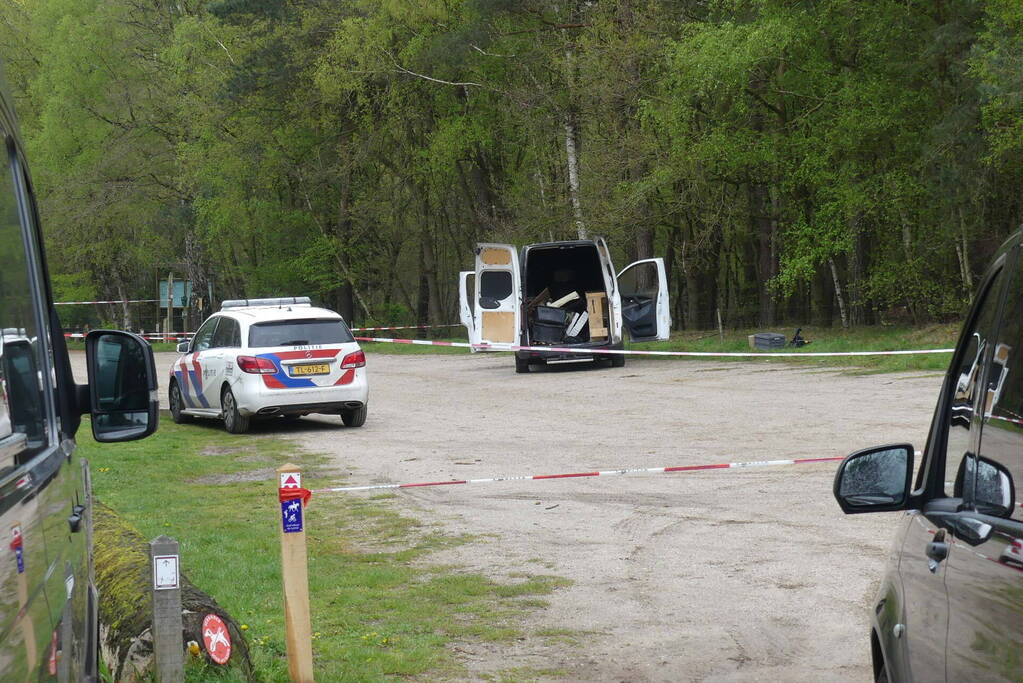 Bestelbus met afval in brand gestoken op parkeerplaats bij bos, twee aanhoudingen
