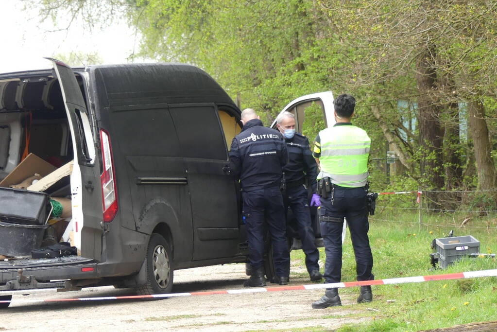 Bestelbus met afval in brand gestoken op parkeerplaats bij bos, twee aanhoudingen