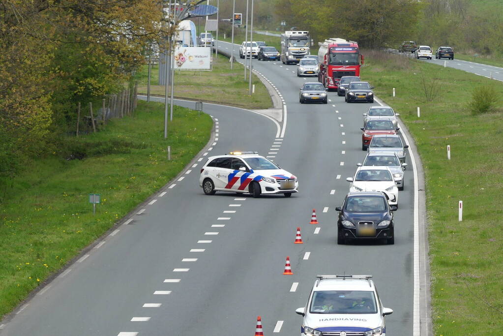 Auto en aanhanger met graafmachine over de kop