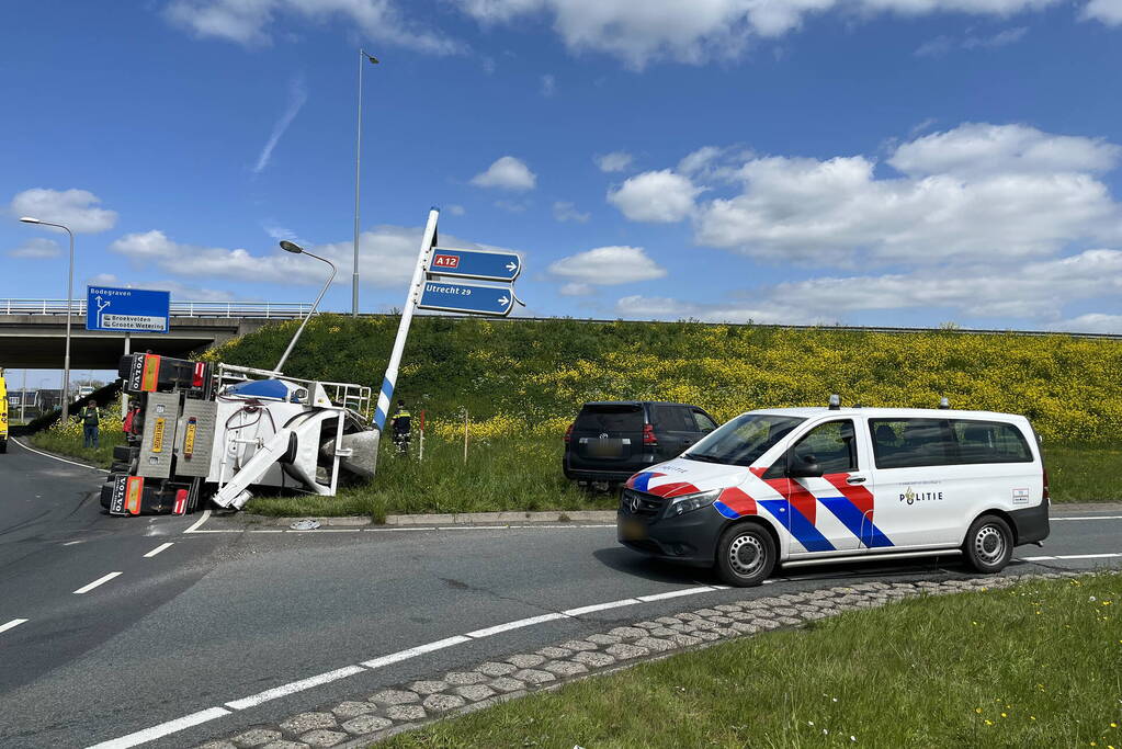 Vrachtwagen met betonmixer oplegger gekanteld