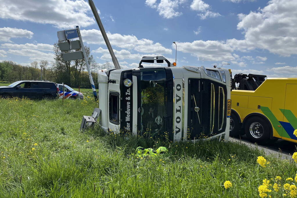 Vrachtwagen met betonmixer oplegger gekanteld