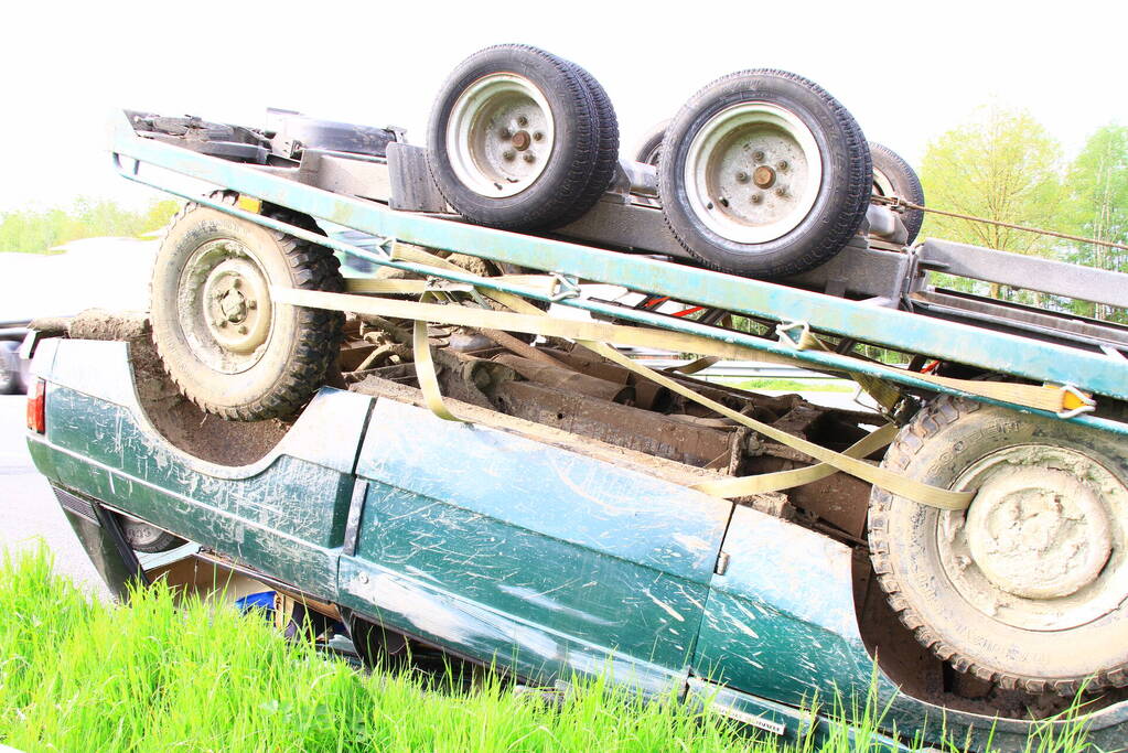 Jeep op aanhanger belandt op de kop