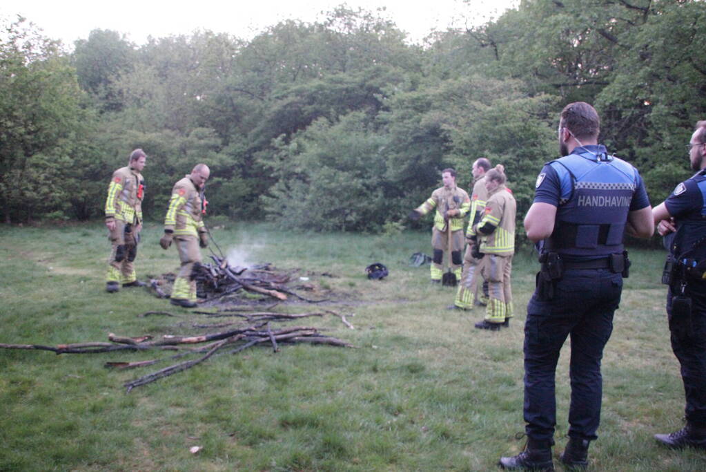 Brandweer blust kampvuur in bos