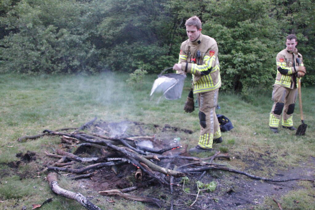 Brandweer blust kampvuur in bos