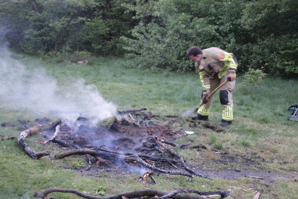 Brandweer blust kampvuur in bos
