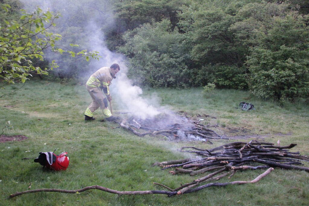 Brandweer blust kampvuur in bos
