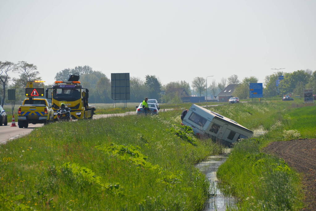 Caravan raakt los van auto en belandt in sloot
