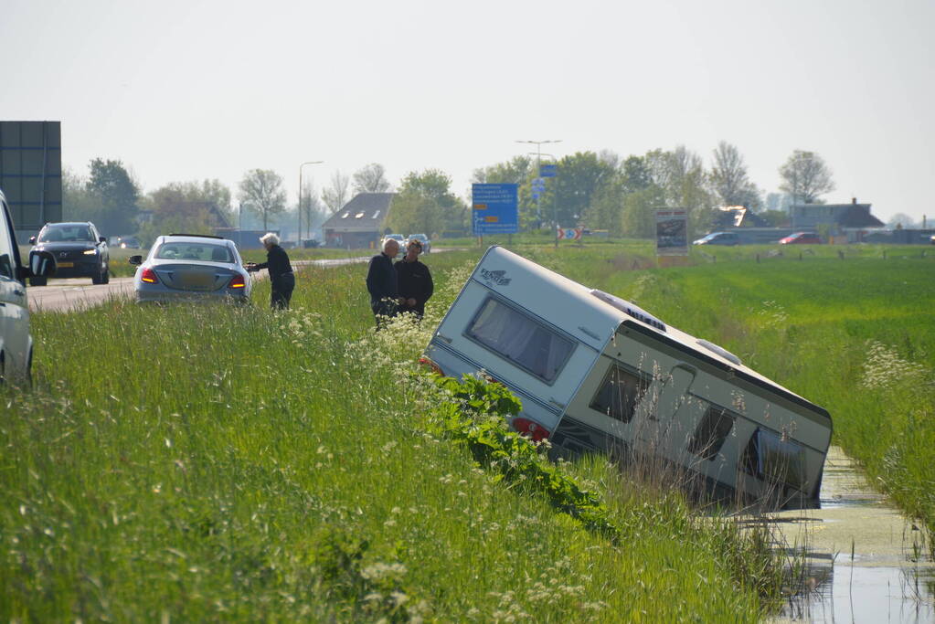 Caravan raakt los van auto en belandt in sloot