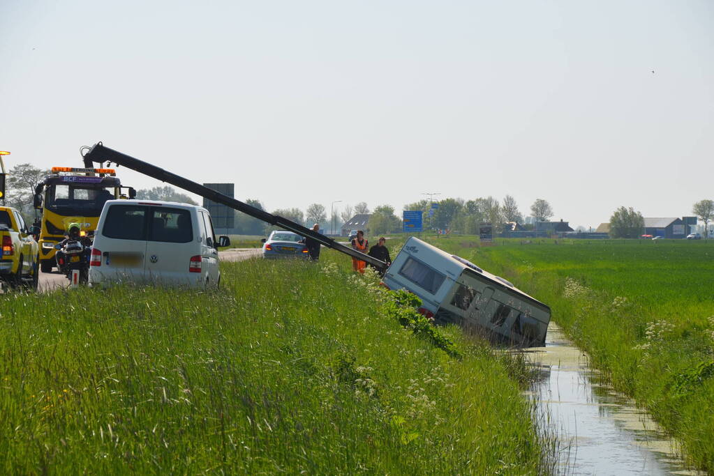 Caravan raakt los van auto en belandt in sloot