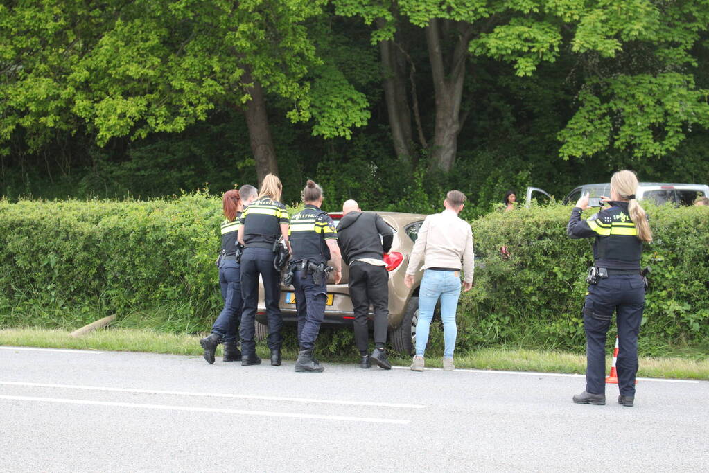 Auto rijdt dwars door heg