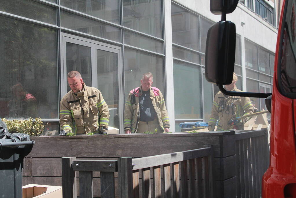 Schade aan vlonder na brand in stapel karton