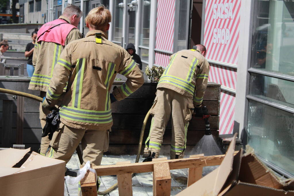 Schade aan vlonder na brand in stapel karton