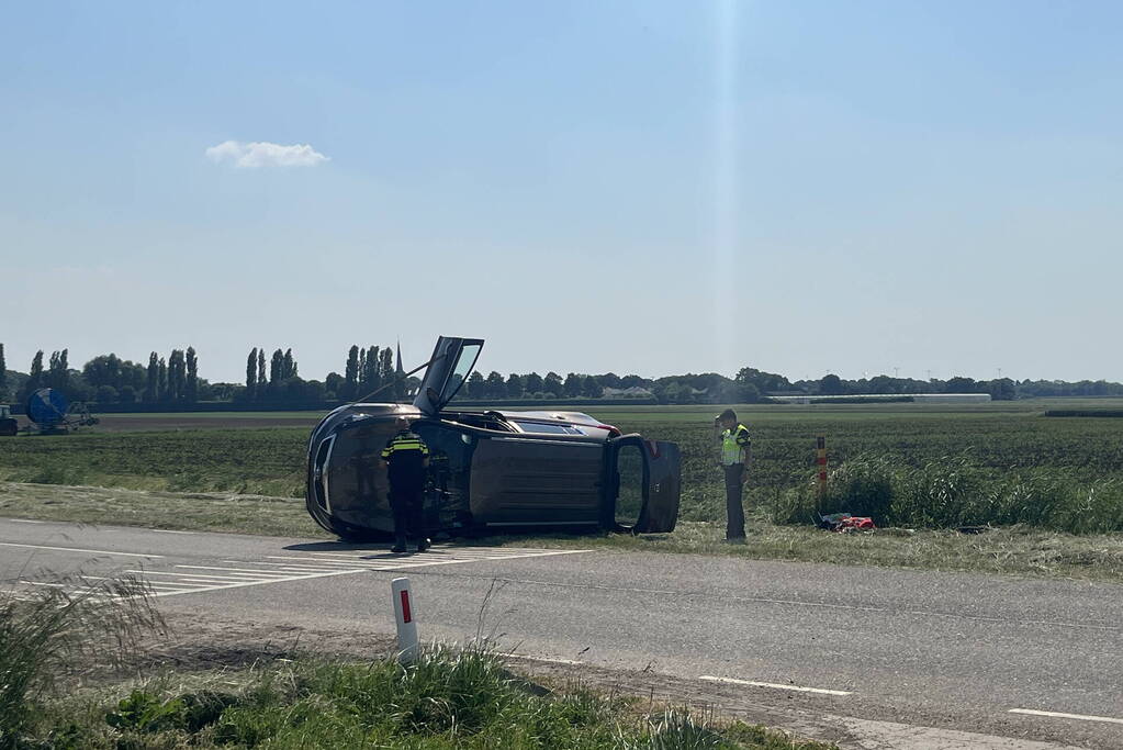 Auto op zijn kant bij botsing