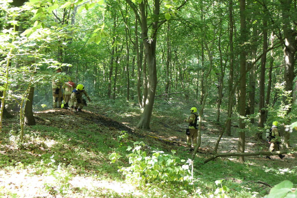 Brandweer blust smeulende delen in duingebied