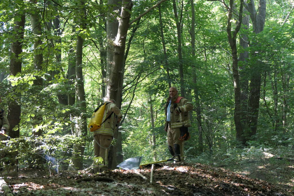 Brandweer blust smeulende delen in duingebied