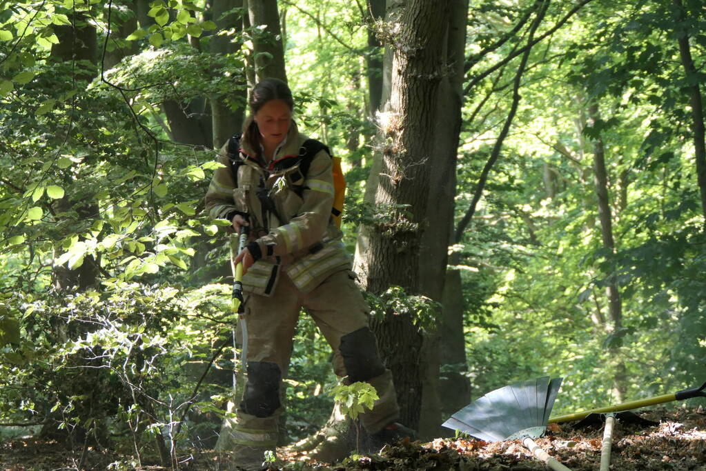 Brandweer blust smeulende delen in duingebied